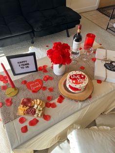 a valentine's day table with a cake, wine and other items on it