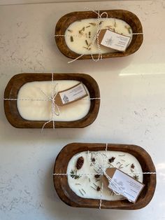 three wooden trays with different types of soap in them on a white counter top