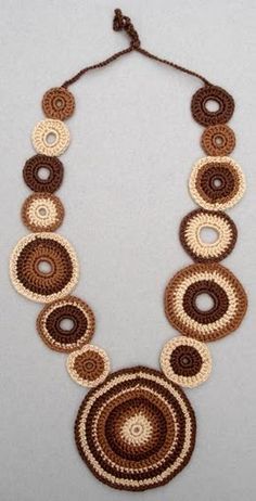 a brown and white crocheted necklace with circles