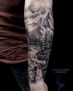 a man's arm with a mountain scene on it