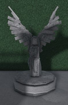 a statue with wings sitting on top of a pedestal in front of a green wall