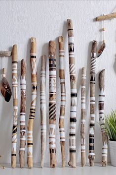 a group of wooden sticks sitting on top of a white table next to a potted plant