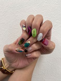 a woman's hands with different colored nail polishes on their fingers and nails