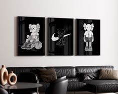 three black and white paintings hang on the wall above a leather couch in a modern living room