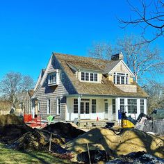 a house that is under construction with dirt piled in front of it and some trees