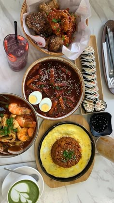 a table topped with plates and bowls filled with different types of food next to drinks