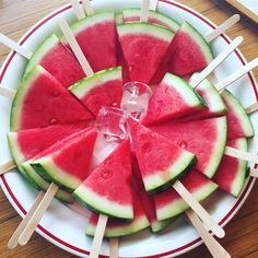 slices of watermelon and popsicles arranged on a plate with toothpicks