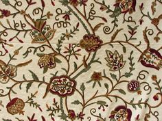 an embroidered fabric with flowers and leaves on it's side, in white background