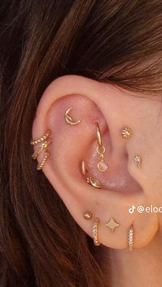 a close up of a person wearing different types of ear piercings on their ears