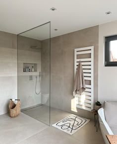 a bathroom with a glass shower door and towel rack