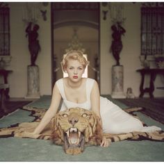 a woman sitting on the floor with a tiger head in front of her and an open mouth