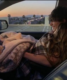 a woman sitting in the back seat of a car holding a baby