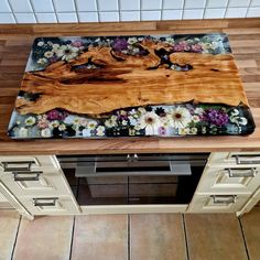 a wooden cutting board sitting on top of a kitchen counter next to an oven door