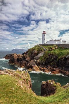 a lighthouse on top of a cliff near the ocean