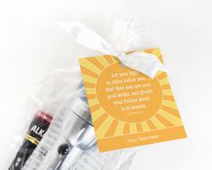 an orange and yellow gift bag with two pens, one black marker and the other white