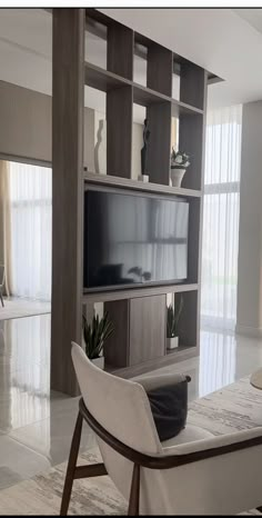 a living room filled with furniture and a flat screen tv on top of a wooden shelf