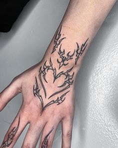 a person's hand with a tattoo design on the middle of their left hand