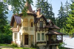 an old style house in the middle of a wooded area with lots of greenery