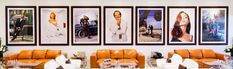 a living room filled with orange couches and pictures on the wall above them,