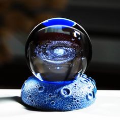 a glass ball sitting on top of a white table next to a black and blue object