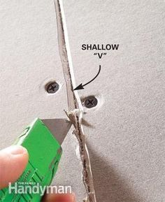 someone is cutting through the hole in the wall with a green gluer and screwdriver