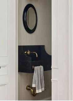 a bathroom with a sink, mirror and towel rack on the door way to another room