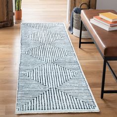 a white and blue rug on the floor in a living room