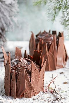 two pieces of chocolate cake sitting in the snow