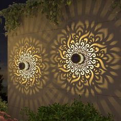 two circular cutouts on the side of a building at night with light shining through them