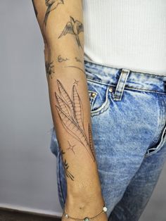 a woman's arm with tattoos on it and some birds flying above her wrist