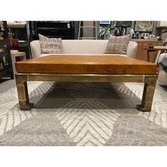 a wooden table sitting on top of a carpeted floor next to couches and tables