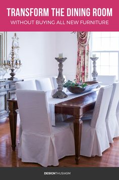 a dining room table with white chairs and a chandelier