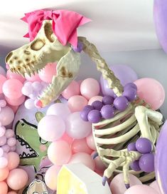 there is a skeleton in the middle of balloons and other items on the table,