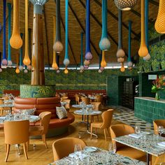 the interior of a restaurant with tables, chairs and lamps hanging from the rafters