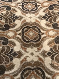 a brown and white rug with an intricate design on it