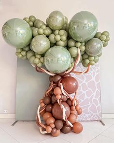 a bunch of balloons that are in the shape of a tree on top of a table