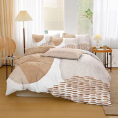 a bed with white and brown comforters in a room