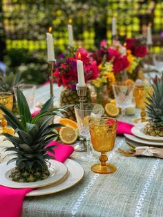 a pineapple centerpiece on a table with plates and glasses in front of it