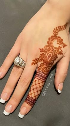 a woman's hand with henna tattoos on it