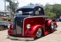 an old red truck parked in a parking lot