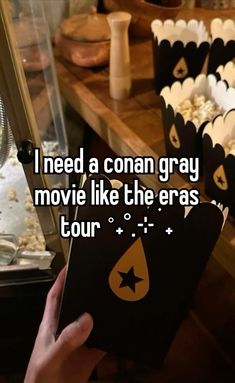 someone holding up a book with the words i need a conan gray movie like the eras