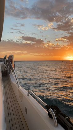 the sun is setting over the ocean on a boat