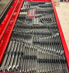 a red truck bed filled with lots of wrenches