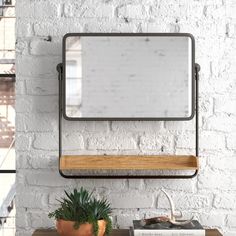 a potted plant sitting on top of a wooden table next to a white brick wall