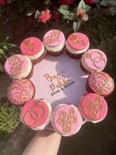 pink and gold decorated cupcakes arranged in a circle