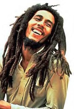 a man with dreadlocks is smiling and holding his hand out to the side