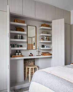 a bedroom with white walls and open shelving