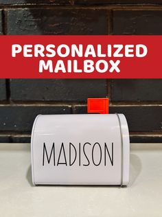 a mailbox with the word personalized mailbox on it in front of a brick wall