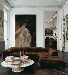 a living room filled with furniture and a painting on the wall