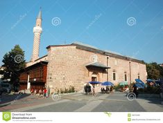 an old brick building with people walking around it